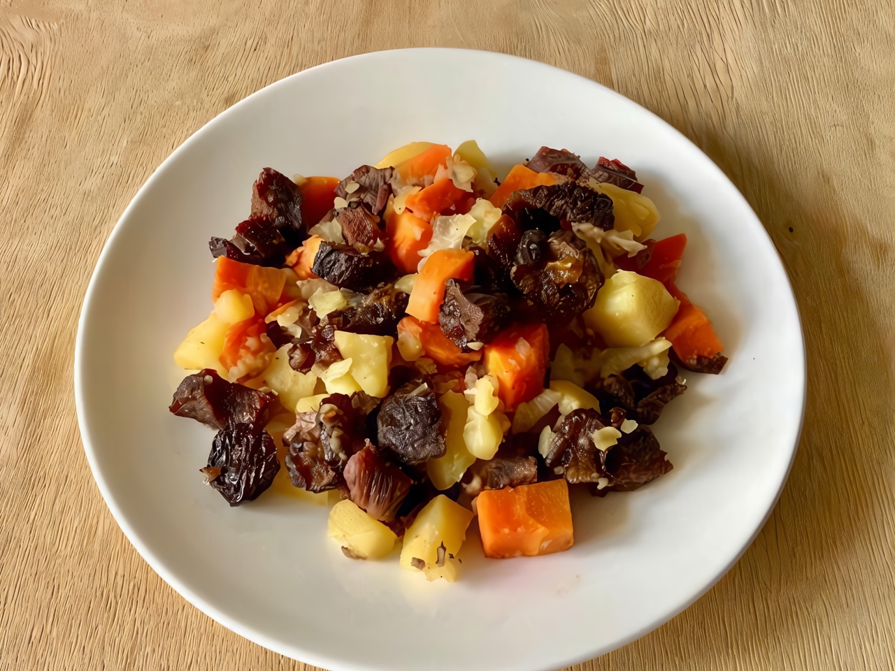 Beef with Prunes on a Vegetable Bed in the Oven